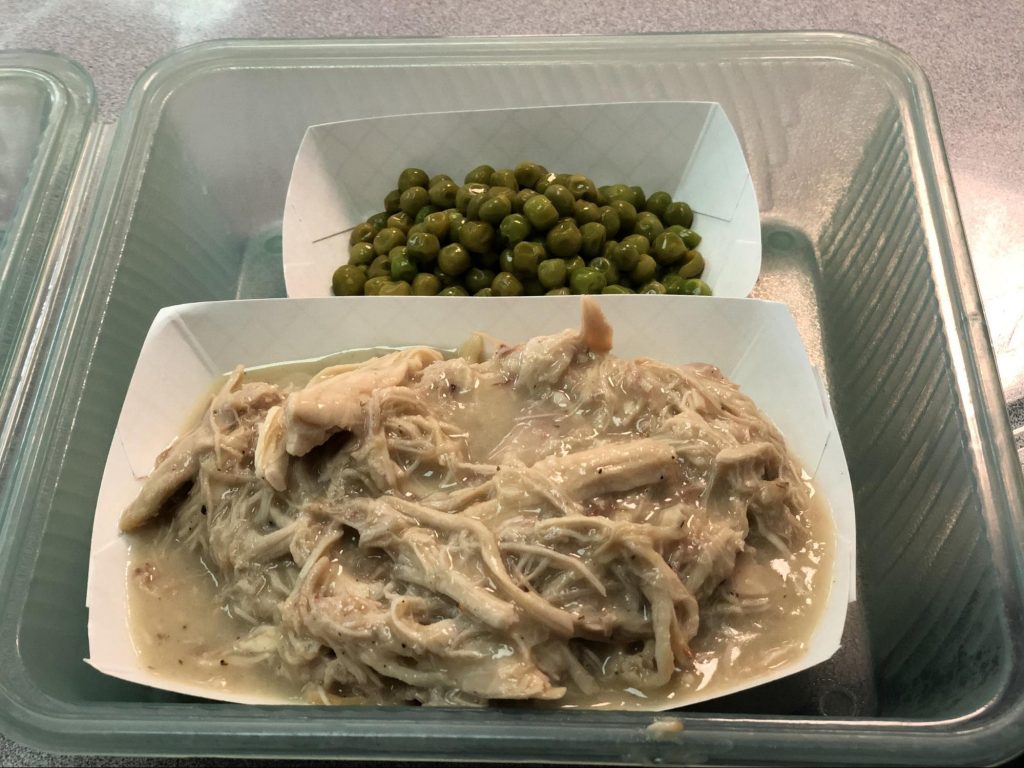 School lunch of chicken and gravy with peas