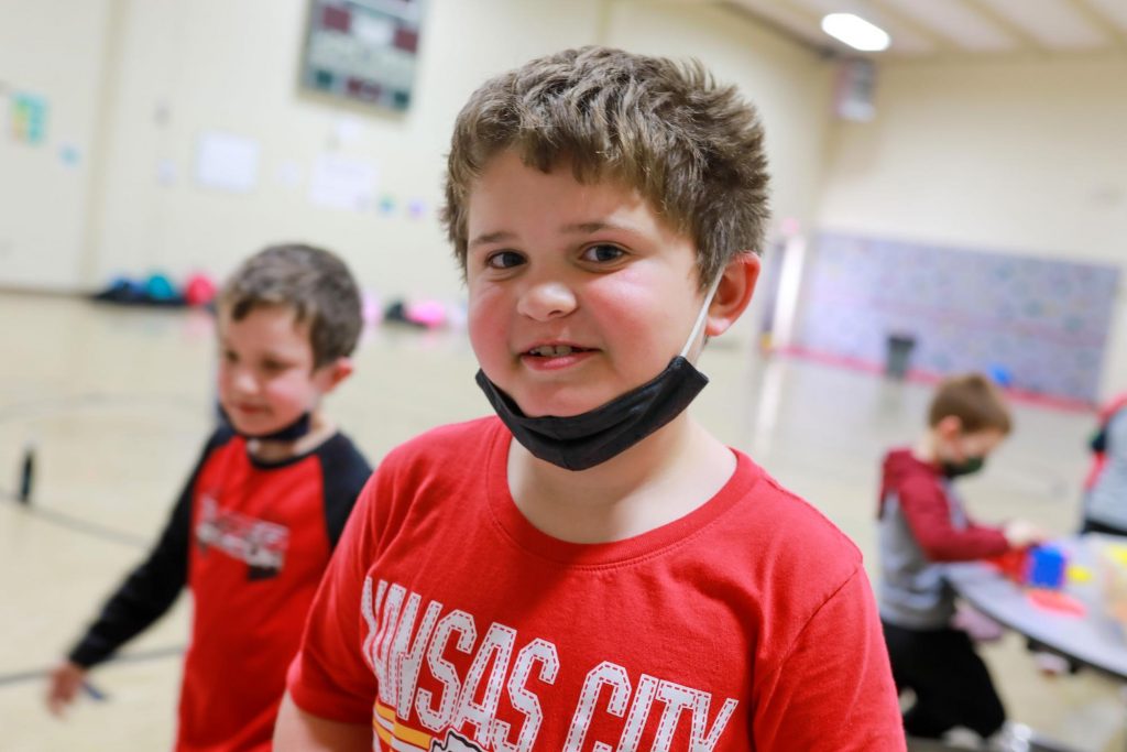 Elementary student smiling in a school gym