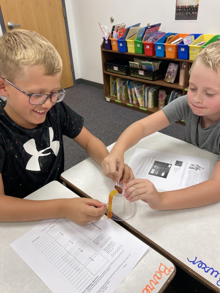 Third grade students work together to complete a teamwork activity.