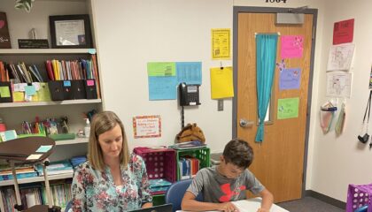 a teacher gives a reading fluency test to a student