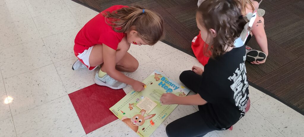 Two first grade math students practice counting with a game.