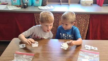 Two first grade math students practice counting with a game.