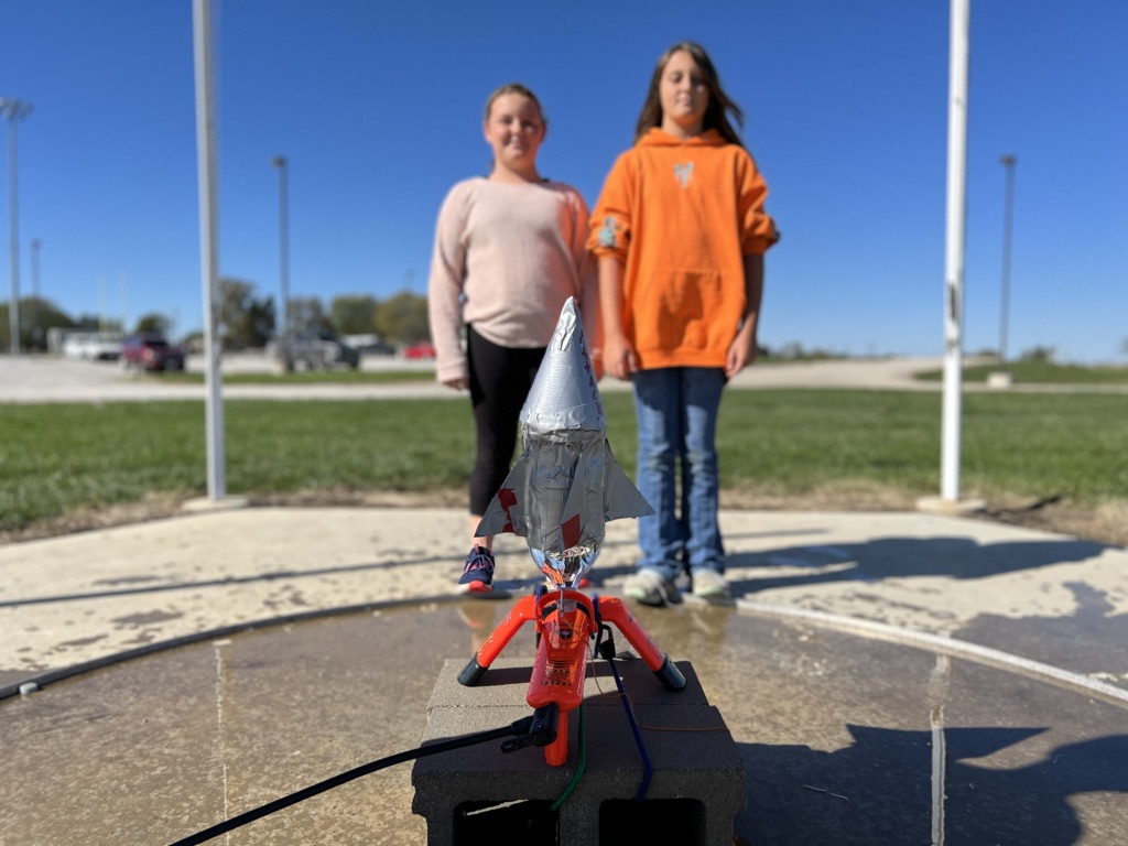 two sixth grade students pose with their final rocket before launch