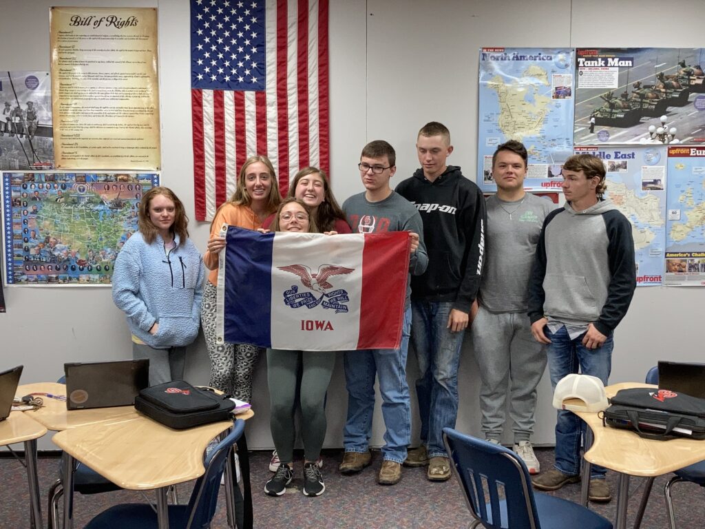 Senior government students hold a flag to celebrate registering to vote