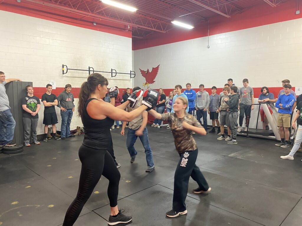 Guest instructor demonstrates proper punch technique in PE class.