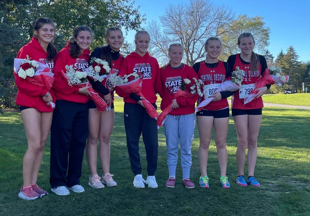 Girls Cross Country team poses with congratulatory flowers at State
