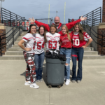 Five high school students gather around a trash can after being recognized for their RED way behavior